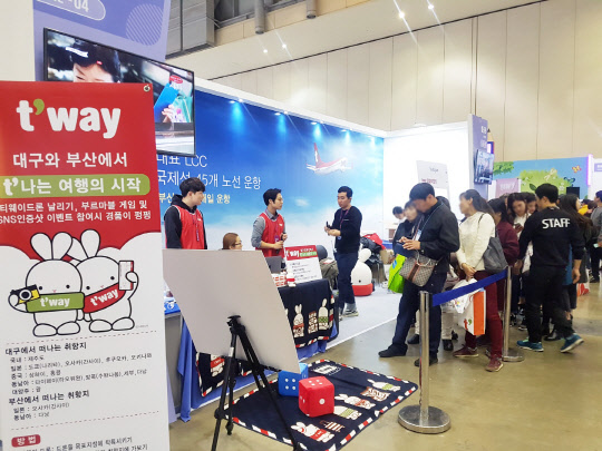 티웨이항공이 지난 1일~3일까지 부산 벡스코에서 열린 하나투어 여행박람회에 참가했다고 4일 밝혔다.  사진은 이번 박람회에서 티웨이항공이 마련한 부스에서 주사위를 던져 나온 숫자만큼 각 칸으로 이동하는 게임에 참가한 관람객의 모습. <티웨이항공 제공>